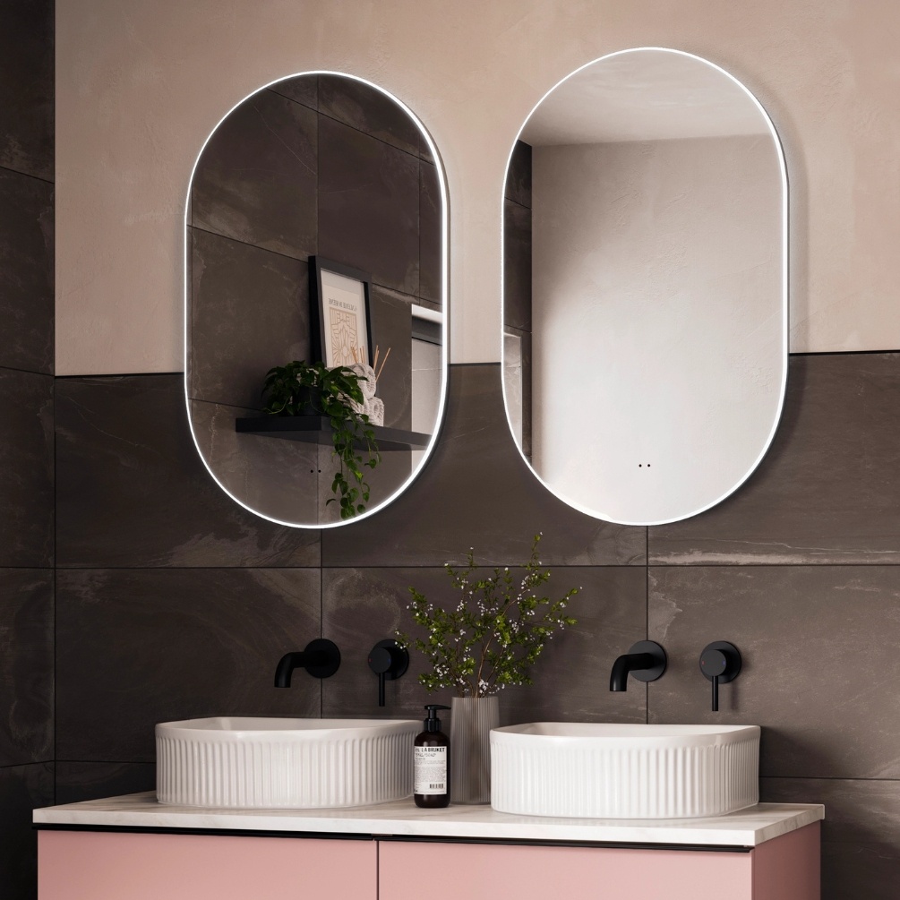 Lifestyle image of two hib. Air Pill 500mm x 800mm LED Mirror side by side and mounted above two basins on a pink vanity unit